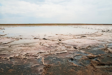 Beautiful natural textural background on a salt lake, river. Salt lake Elton, Russia, before rain and thunder, sunset on the water, solitude, silence, calm