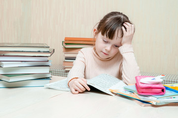 schoolgirl reluctantly reads a book. one hand props head