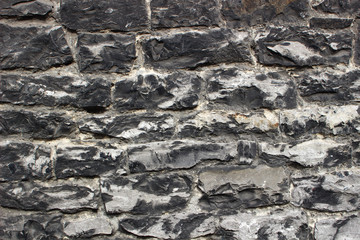 An abstract texture of wall for design and background. A medieval masonry from large grey stones. Europe