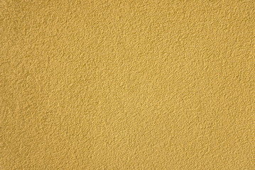 Sample of exterior plaster in lamb style, small granules,  yelow color, facades of houses, background and texture
