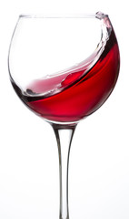 Wine glass with red wine on a white background splash