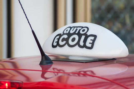 closeup of french driving school panel on the car roof , text in french "auto ecole", traduction in english "driving school"