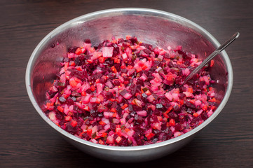 A full bowl of salad with a vinaigrette spoon