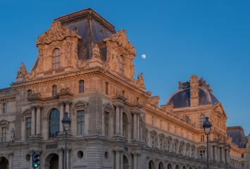 Obraz premium Paris, France - 02 17 2019: The roofs of the buildings of the Louvre Museum at sunset with moon