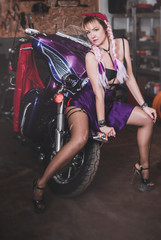 Stylish blond woman posing with motorcycle.