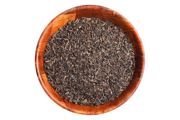 Black tea dry leaf in wooden bowl isolated on white studio background.