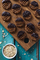 Homemade healthy raw vegan gluten and sugar free cookies with oats, chocolate and himalayan salt on blue background