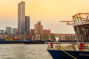 ROTTERDAM, NETHERLANDS - APRIL 13, 2018: Rotterdam embankment with skyscrapers and ships and the river Nieuwe Maas. Rotterdam is the second-largest city and a municipality of the Netherlands.