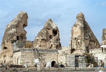 Fototapeta na wymiar The view of three collapsing rock pillars with dovecote cave inside in Goreme city of Cappadocia region, Turkey