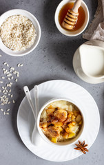 Rice pudding or porridge and fruits (apple, pear, banana and raisins) with honey or maple syrup and spices. Healthy breakfast or dessert.  