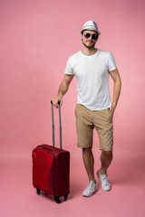 Man traveler with suitcase, passport and ticket on color background.