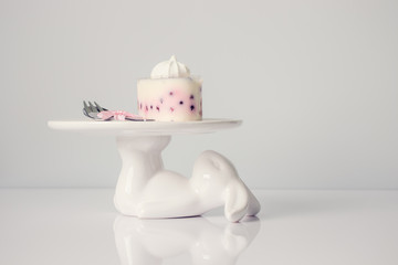 Dessert of mascarpone and wild berries on Easter stand on a light background.