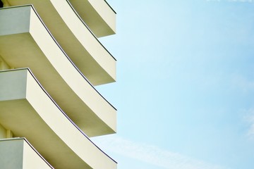 Modern white building with balcony on a blue sky