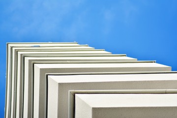 Obraz premium Modern white building with balcony on a blue sky