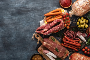 Assortment of Sausage and ham . Assorted meat products, including smoked sausages, ham and salami with vegetables and spices - obrazy, fototapety, plakaty