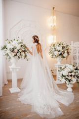 Photo from back Beautiful young woman in white wedding dress smiling