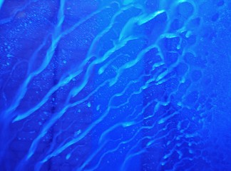 Wasser-Rinnsal an blauer Scheibe