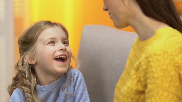 Laughing cheerful girl telling smiling mother funny stories, trustful relations