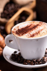  coffee cup close-up over dark roasted coffee beans