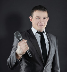 young successful businessman with microphone.isolated on black