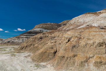 Fototapeta premium Scars in the ground, multi coloured rings and red rocks mean your in the Badlands, Drumheller, Alberta, Canada
