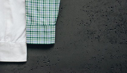 Cuffs from business shirts on a dark background. Vertical sleeves from shirts in green, blue and white. The concept of fashion and sale of luxury clothes.