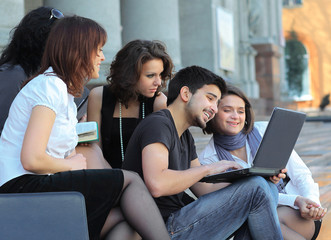 group of fellow students with books and laptop