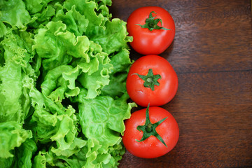 Tomatoes and lettuce on wooden background