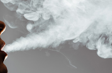 Close-up of a man blowing smoke from his mouth. Concept of smoking cigarettes, smoking...