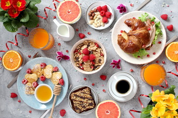 Breakfast food table. Festive brunch set, meal variety with pancakes, croissants, juice, fresh...