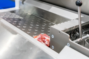 Close up pork or meat sliced on metal rail transport food of automatic and precision slicer machine for industrial food manufacture