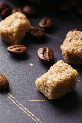 Black fried coffee beans on dark textured background
