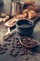 Black fried coffee beans on dark textured background