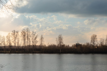 Fototapeta premium View of the wide river on a cloudy day in early spring