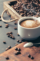 Black fried coffee beans on dark textured background