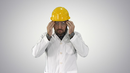 Transparent safety glasses in hand Worker trying on protective glasses on gradient background.