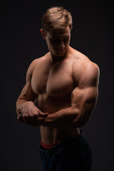 Fototapeta premium Athlete, bodybuilder, on black. Gym advertising, fitness, sports club. Healthy lifestyle concept