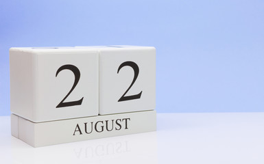 August 22st. Day 22 of month, daily calendar on white table with reflection, with light blue background. Summer time, empty space for text