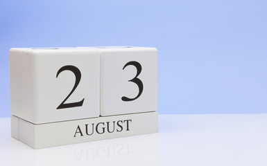 August 23st. Day 23 of month, daily calendar on white table with reflection, with light blue background. Summer time, empty space for text