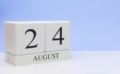 August 24st. Day 24 of month, daily calendar on white table with reflection, with light blue background. Summer time, empty space for text
