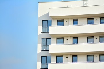 Modern white building with balcony on a blue sky