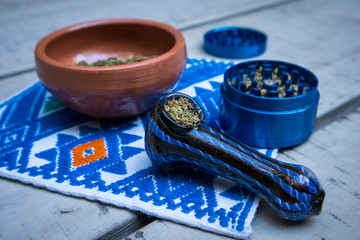 Marijuana in Blue Pipe with Grinder and Bowl of Cannabis