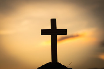 Silhouette of crucifix cross at sunset time with holy and light background.