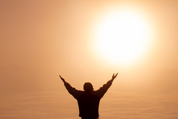 Fototapeta premium Man thank God on the mountain at sunrise in the morning,Praying for blessings from God in the morning.