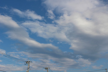 雲が浮かぶ空と電柱