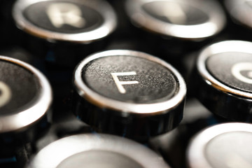 An extreme close-up or macro shot of a round F key on a vintage-inspired retro-style clicky black-and-silver metal typewriter keyboard.