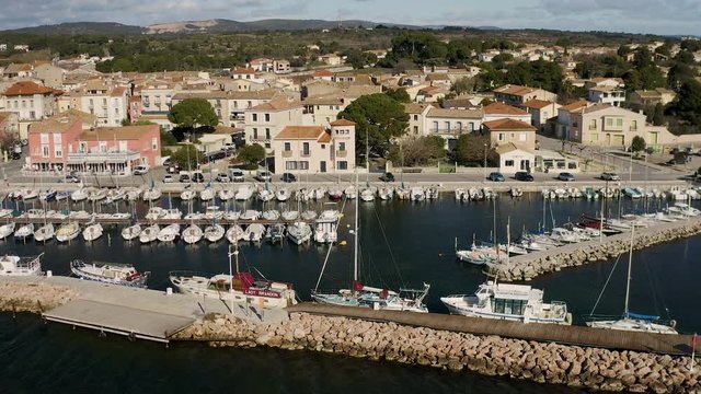Left to right traveling over Bouzigues port sunny day sailing boats and old city Thau France