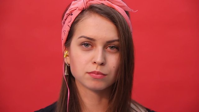 Girl chews and bursts the cud on a red background
