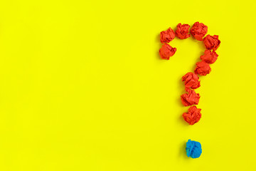 Question mark lined with crumpled paper on yellow background top view copy space