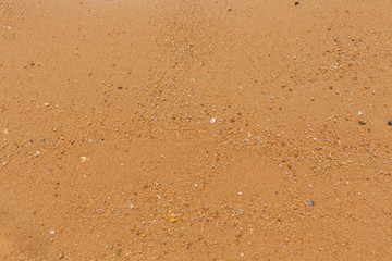 Yellow beach sand with small stones texture